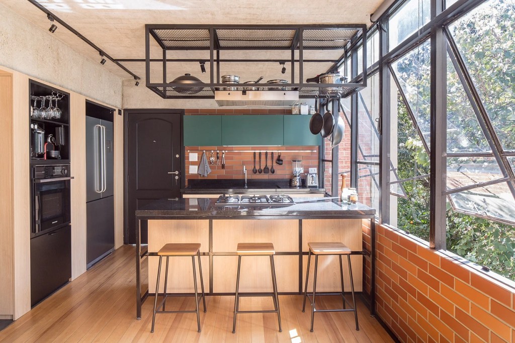 Cozinha com banqueta e bancada; piso de madeira; armário azul;