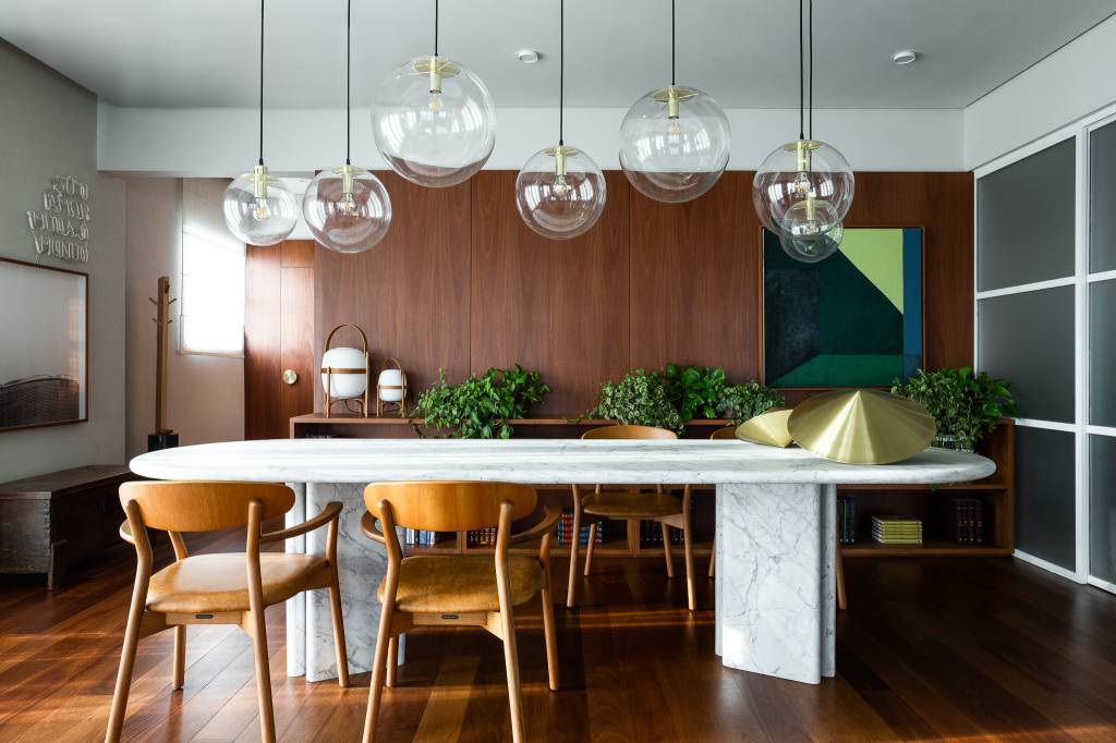 Sala de jantar com mesa em granito e luminárias em vidro