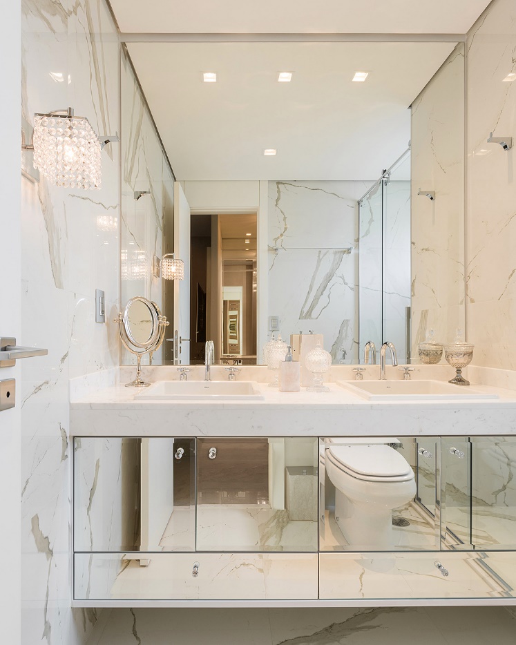 Banheiro com parede em mármore e espelho