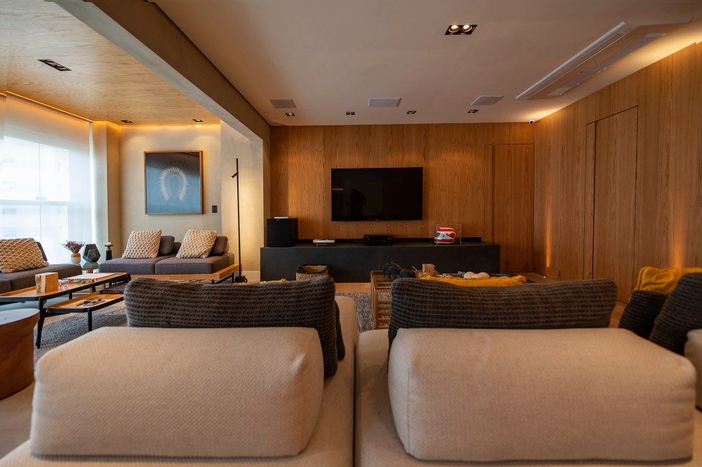 Sala de tv com sofás e poltronas
