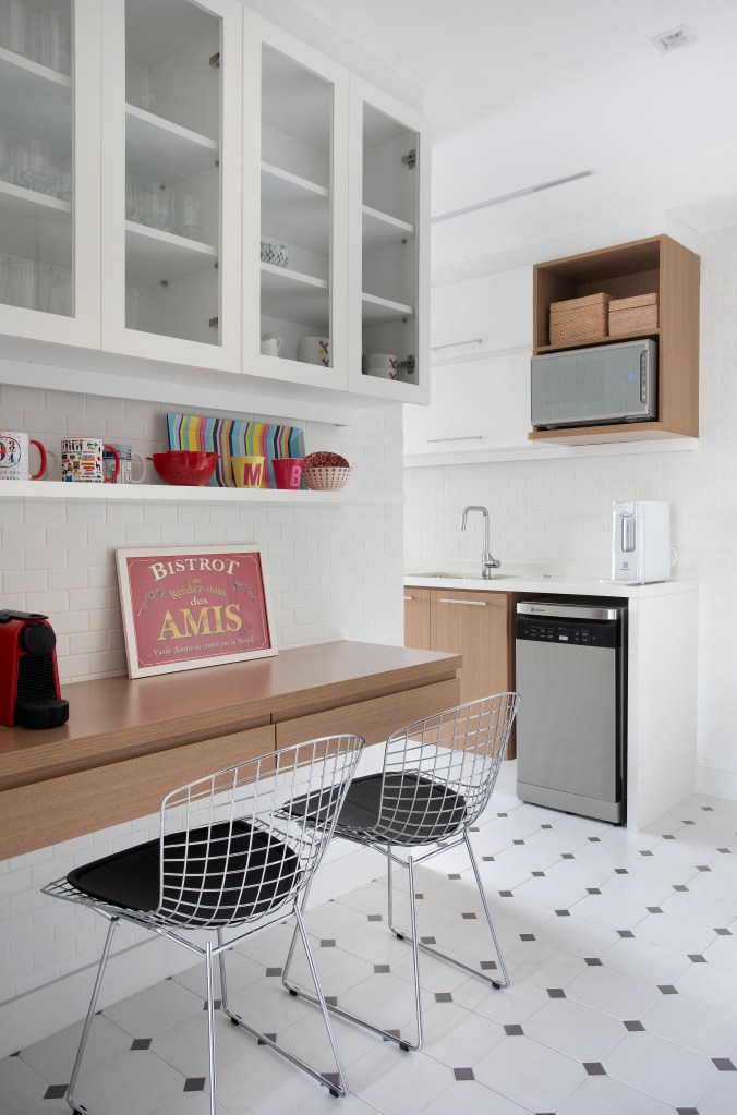 Cozinha com piso geométrico; marcenaria branca; bancada de madeira