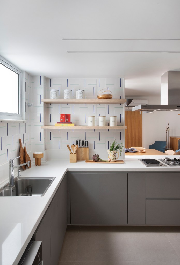 Cozinha; azulejo; backsplash; prateleira de madeira; cozinha em L; bancada; armário cinza