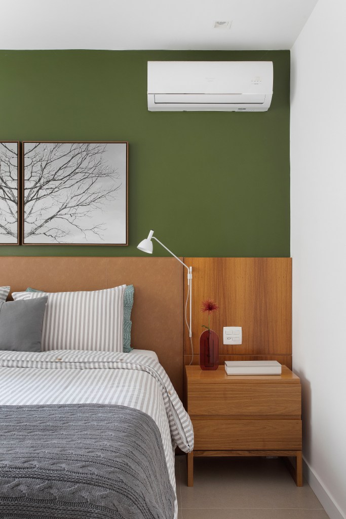 Quarto; parede verde; cabeceira de madeira; quadro; mesinha lateral