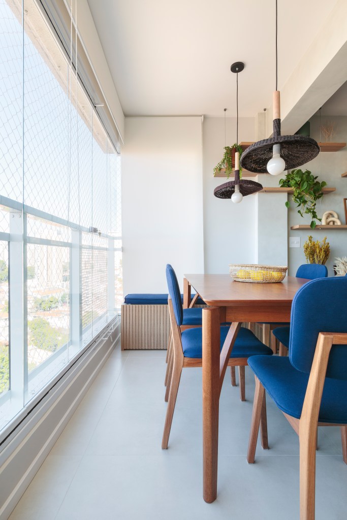 Varanda; varanda integrada; varanda fechada com vidro; mesa de madeira; cadeira azul