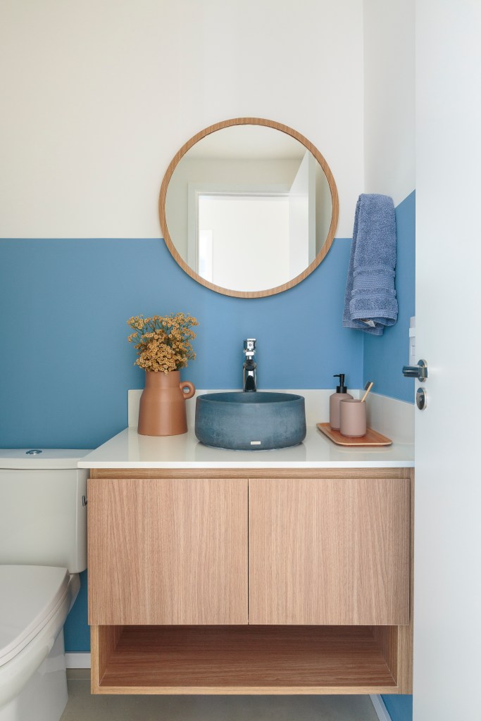Banheiro; banheiro com meia parede; parede azul; cuba azul; espelho redondo