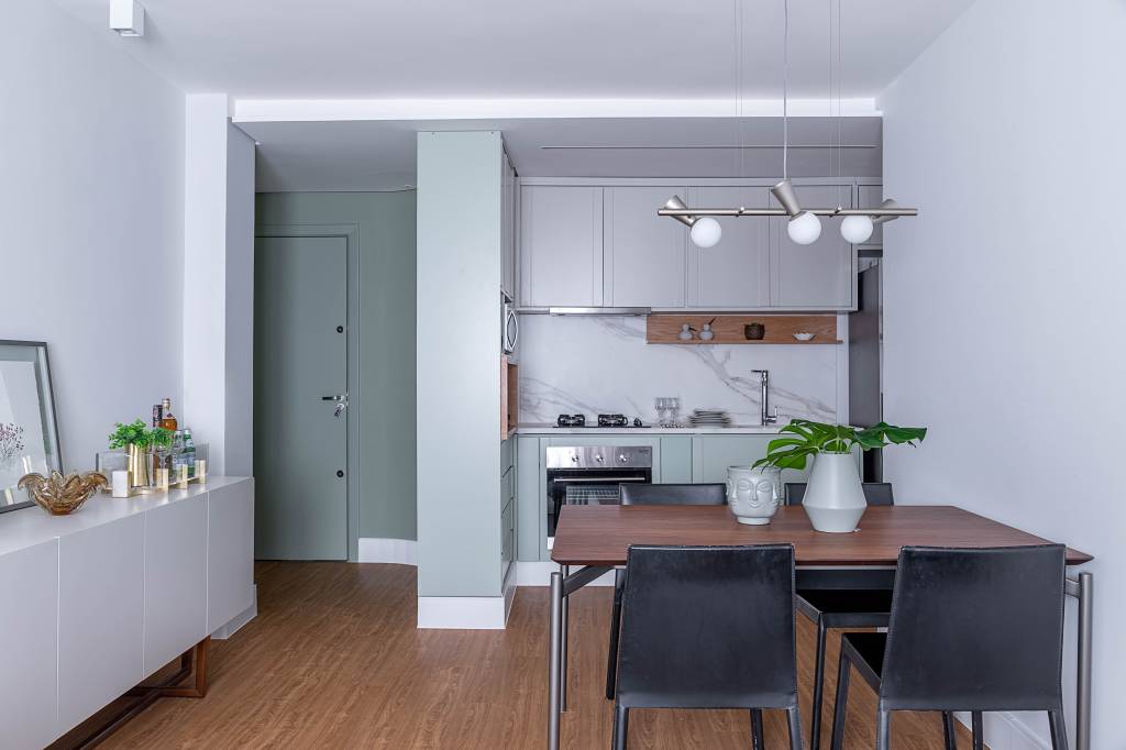 apto-flat-de-58-m²-tem-area-social-integrada-e-marcenaria-colorida-na-cozinha-carina-dal-fabbro-projetou-imovel-para-atender-as-demandas-de-um-casal-brasileiro-que-vive-entre-montreal-no-canada (5) ape apartamento flat carina dal fabbro sala estar jantar mesa luminaria cadeira