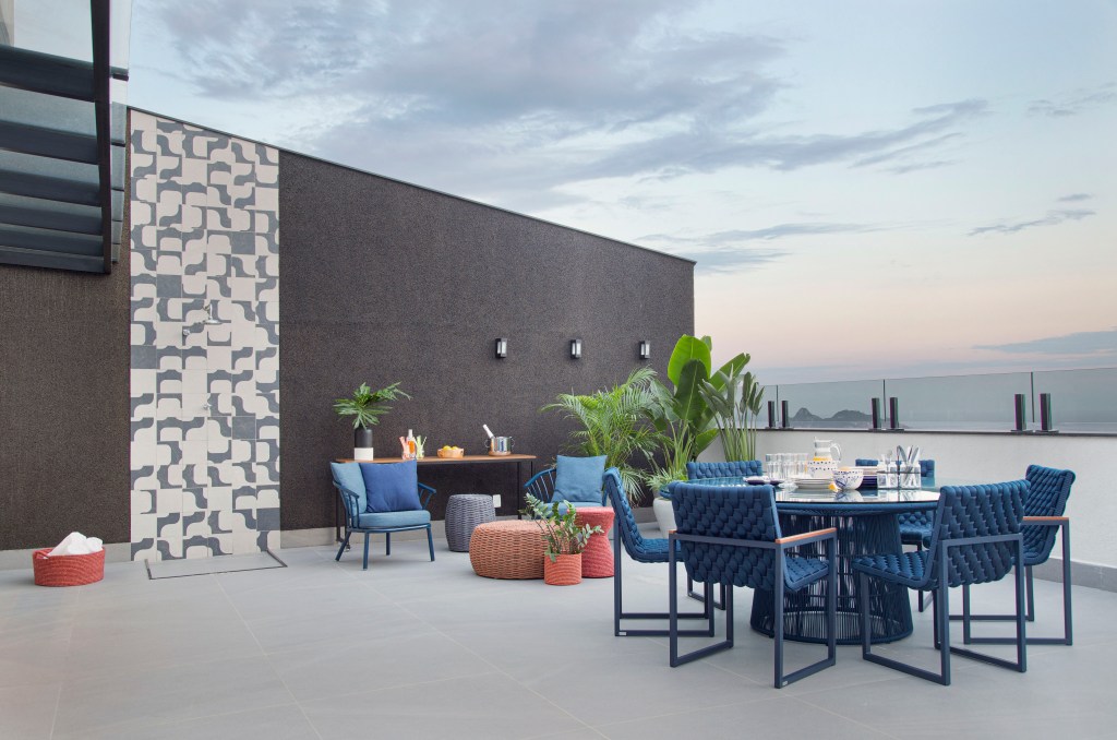 Terraço; varanda; mesa redonda; cadeiras azuis; painel de cerâmica