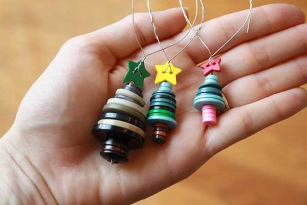 Empilhando botões você consegue criar pequenas árvores de Natal para decorar.