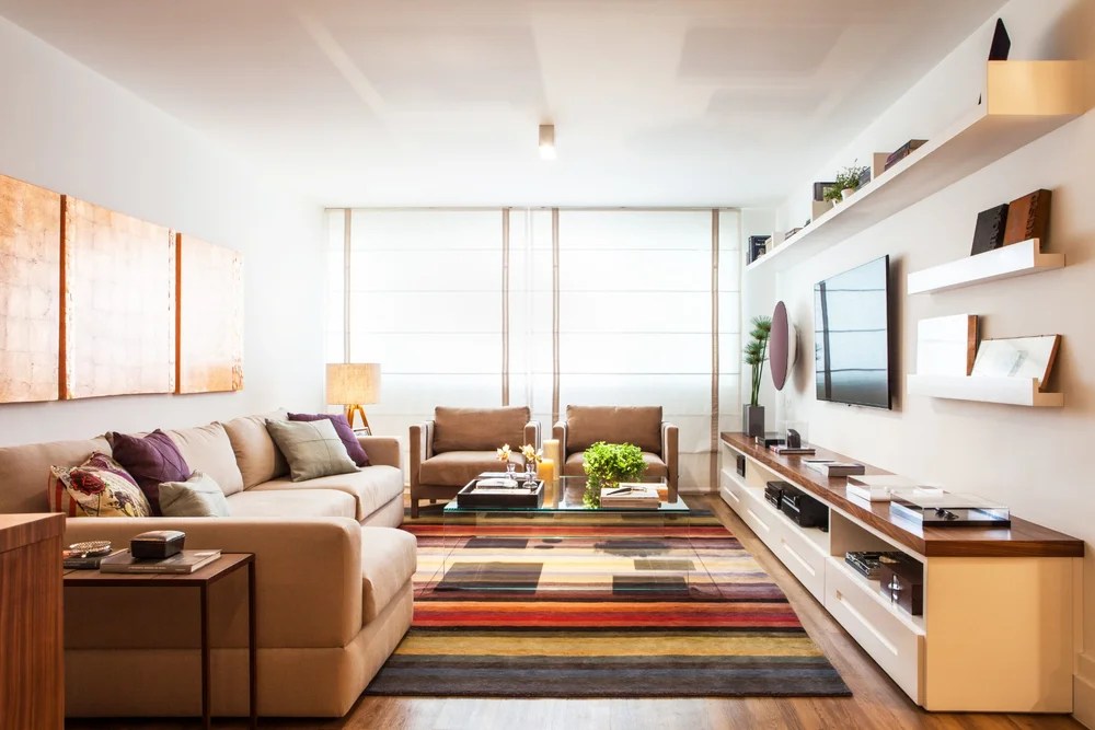 Sala de estar; tapete colorido; painel de madeira com prateleiras