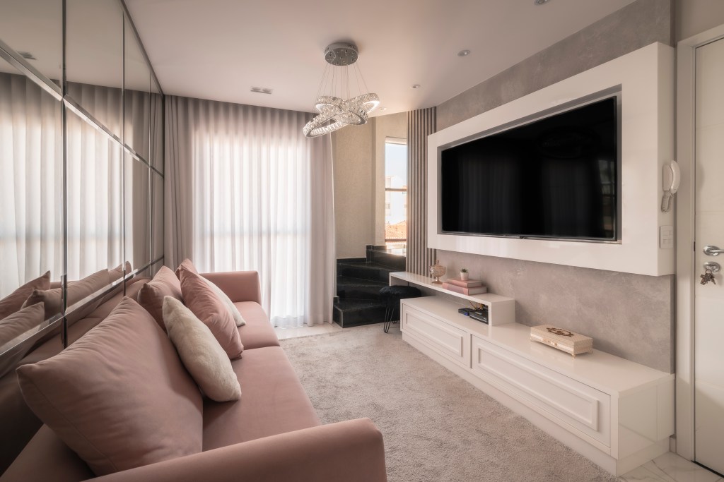 Sala de estar; espelho; luminária; sofá rosa; tapete