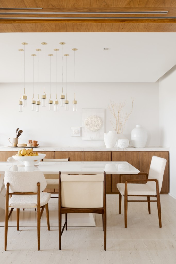 Sala de jantar; mesa branca; cadeira branca; buffet de madeira; luminaria
