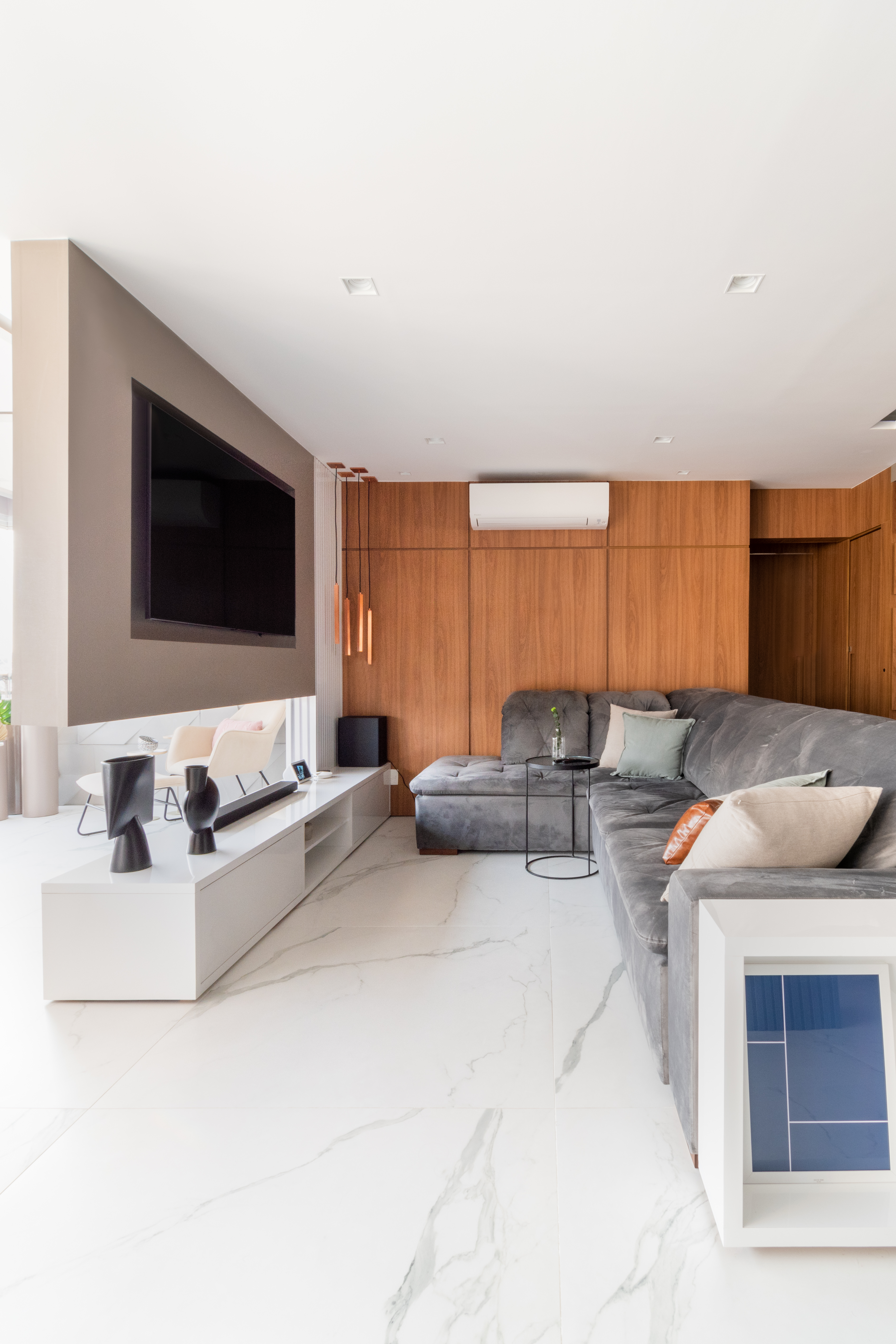 Sala de estar integrada; sofá cinza; painel de madeira; painel de madeira com led; aparador branco; piso de porcelanato