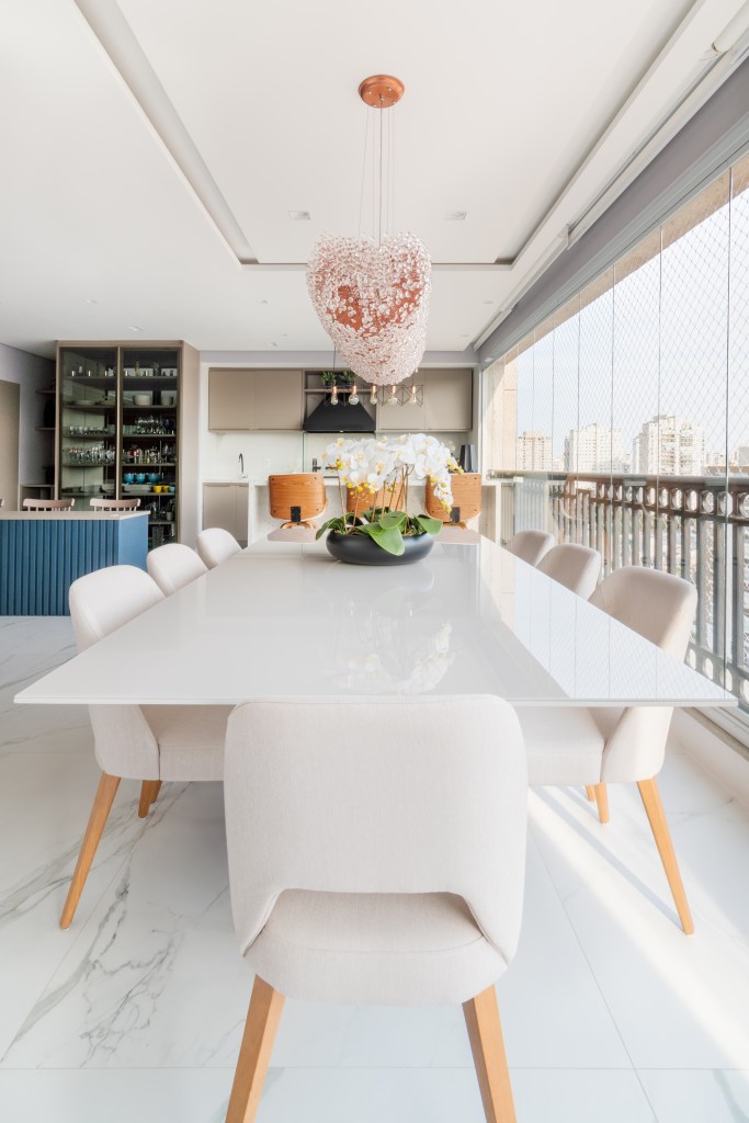 Varanda integrada; varanda gourmet; mesa de jantar branca; tampo de laca; lustre; cadeiras brancas