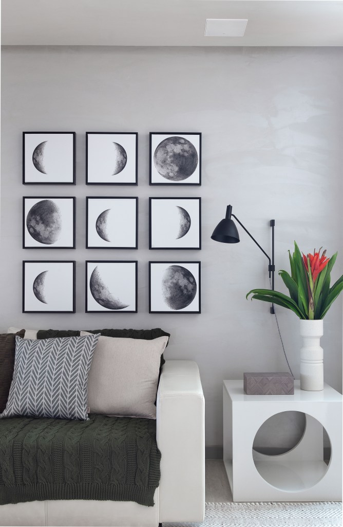 Sala de estar; gallery wall; quadros; quadros de lua; mesinha lateral; sofá preto;