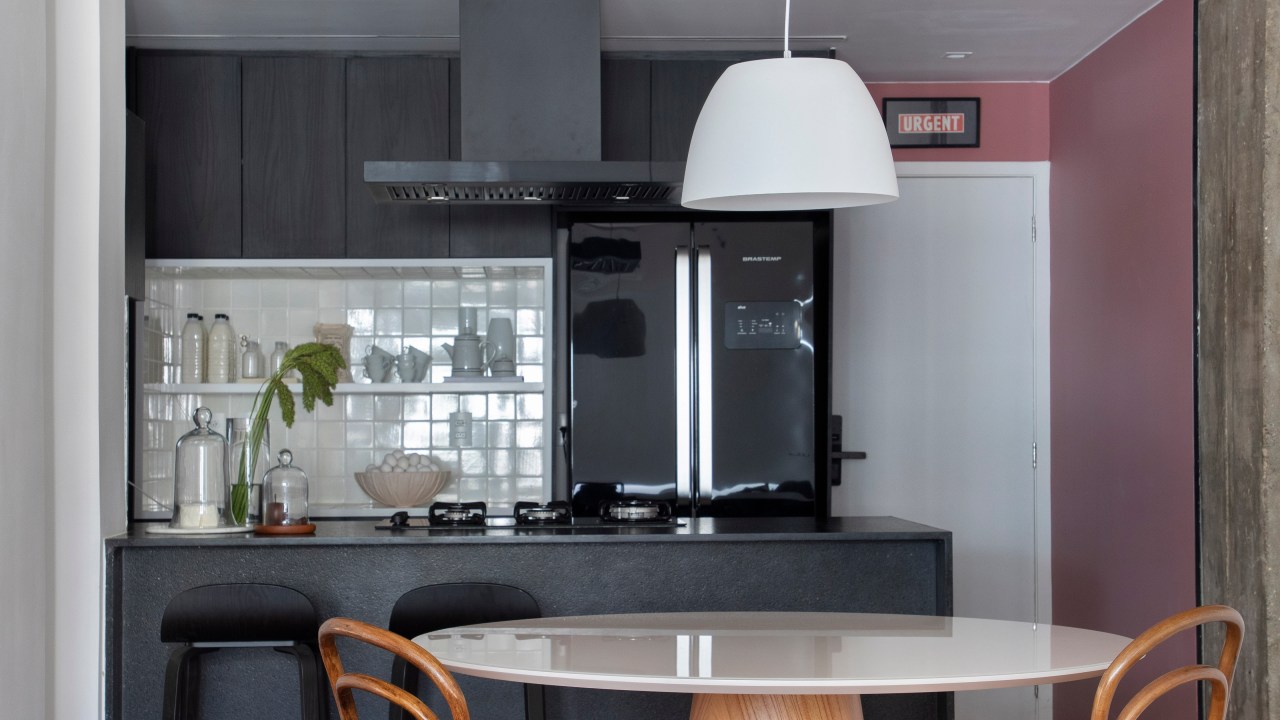 Sala estar; sala de estar integrada com cozinha; sala de estar integrada com jantar; viga de concreto aparente; mesa redonda; cozinha preta; cozinha preta e branca