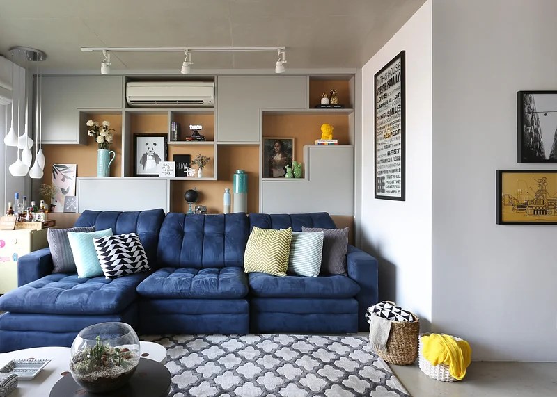 Sofá colorido; sofá azul; tapete estampada; estante com nicho