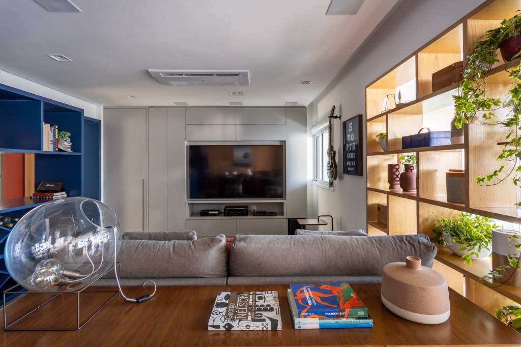 Apê apartamento 170 m² cores revestimentos superfícies móveis Marina Carvalho sala estante tv azul sofa porta camuflada
