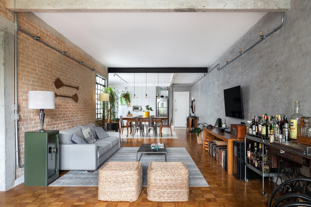 Apartamento 180 m² biofilia estilo urbano industrial Espacial Arquitetos sala cozinha parede de tijolinhos mesa cadeira plantas sofa tv