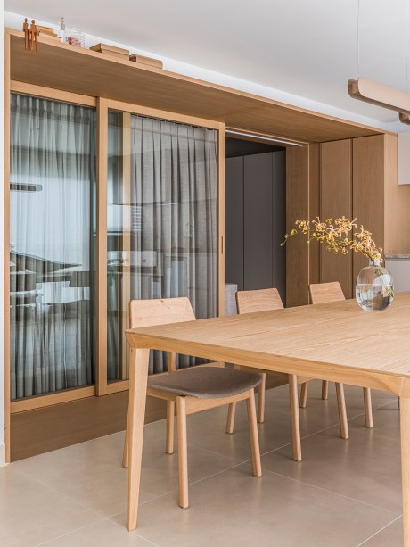 Apê minimalista de 110m² ganha pórtico de madeira entre varanda e sala