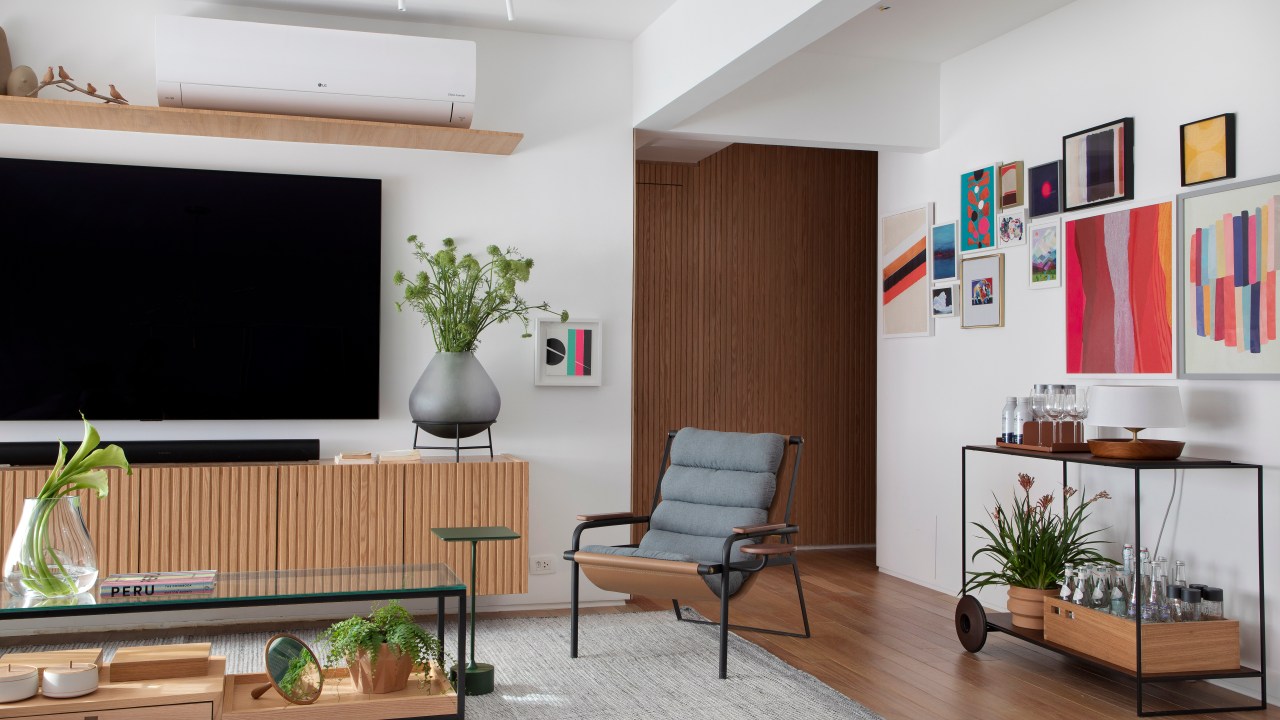 Sala; sala de tv; rack de madeira; tapete; poltrona; mesa de centro
