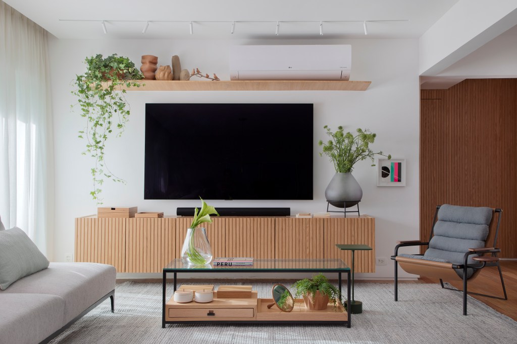 Sala; sala de tv; rack de madeira; tapete; poltrona; mesa de centro