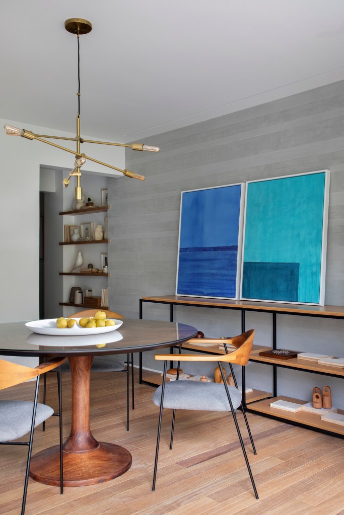 Sala de jantar; mesa redonda; quadro azul; luminária; parede cinza