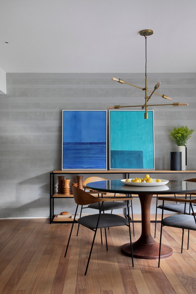 Sala de jantar; mesa redonda; quadro azul; luminária; parede cinza