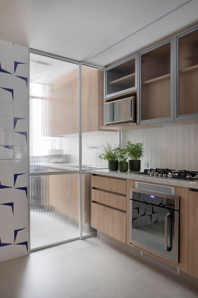 Cozinha; parede de azulejo; lavanderia; porta de correr de vidro