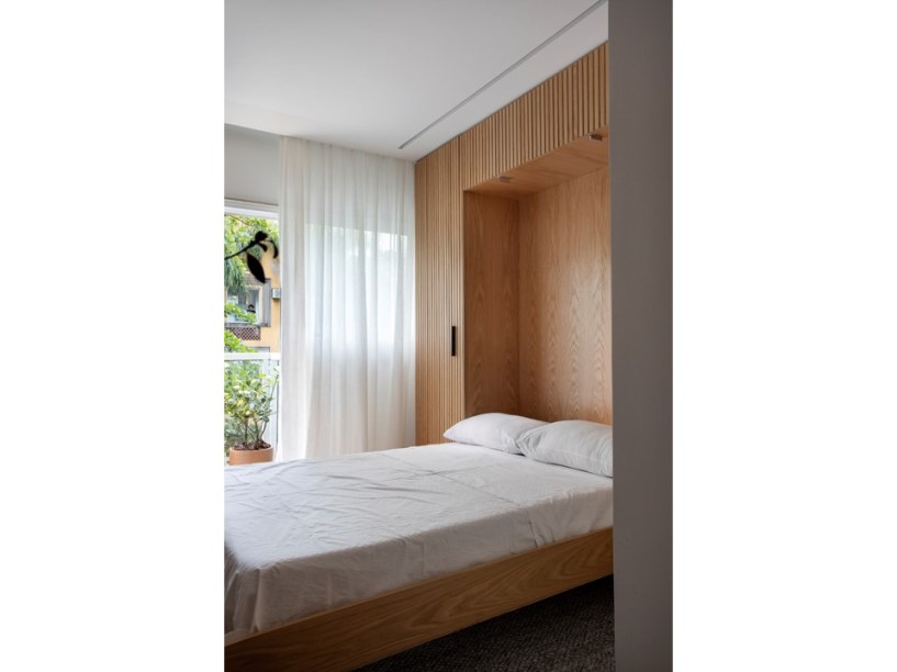 Apê de 160m² tem cama retrátil “escondida” em painel de madeira ripada