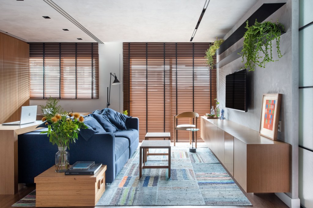 Sala de estar; persiana de madeira; sofá azul; tapete azul