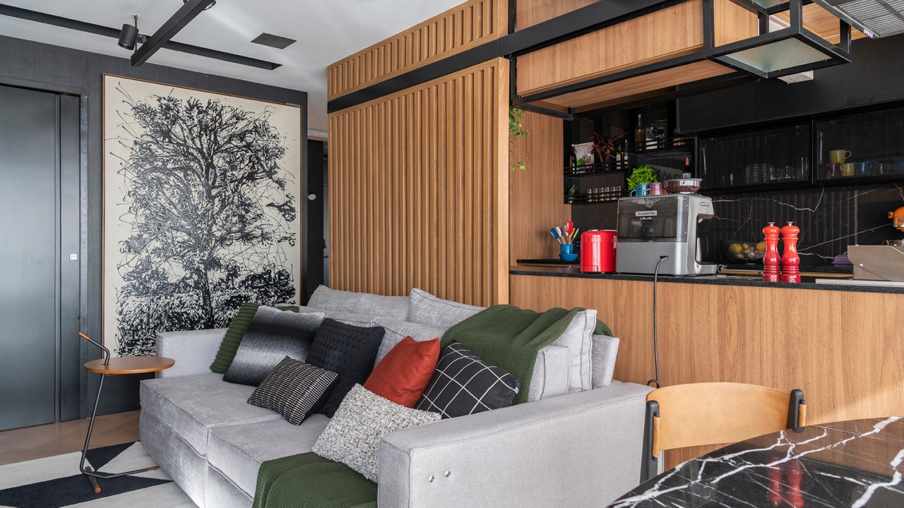 Apê 85 m²piloto de avião tecnologia Nossa Casa Arquitetura sala integrada cozinha painel de madeira ripado quadro sofa
