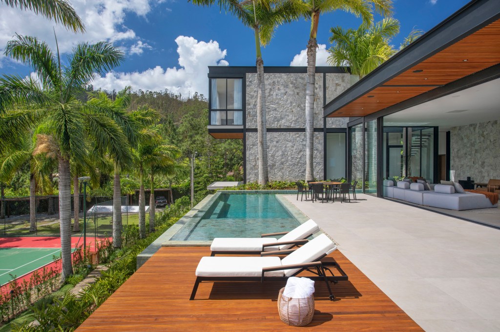 Casa; casa de campo; piscina; área externe; deck de madeira; espreguiçadeira branca; palmeira