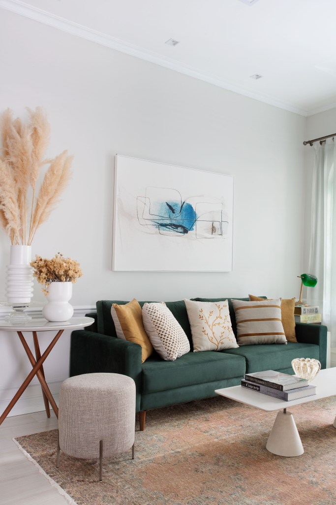 Sala de estar; sala de estar pequena; sofá verde; mesa lateral; quadro em cima do sofá