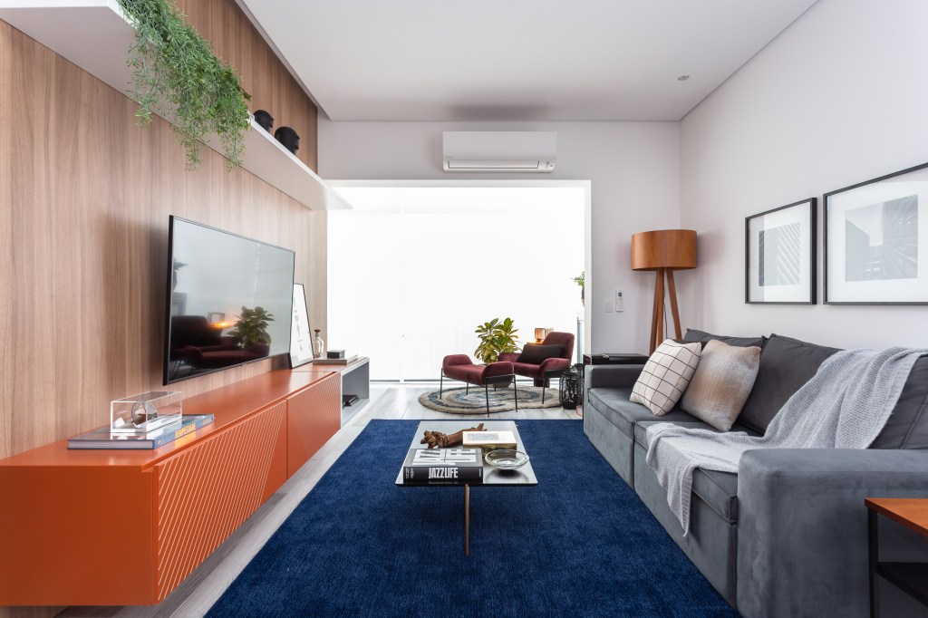 Laranja na decoração; sala de estar; sala de tv; tapete azul; rack laranja