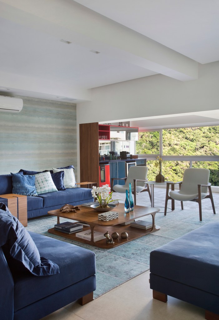 Sala de estar; varanda integrada; sofá azul; mesa de centro de madeira