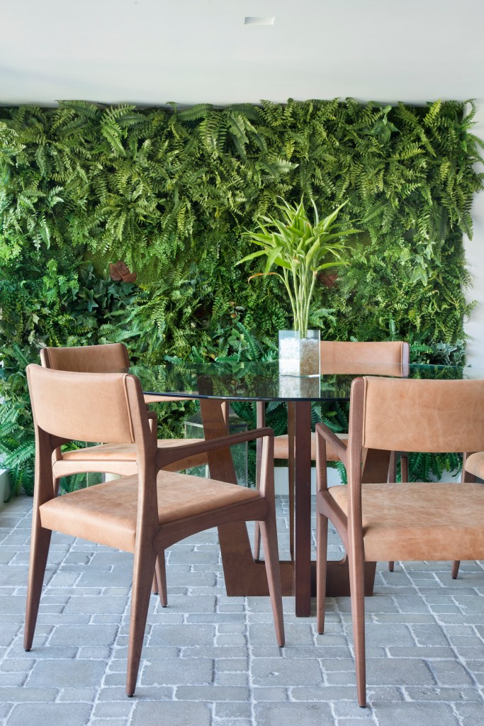 Jardim vertical; mesa redonda com tampo de vidro; cadeira de madeira