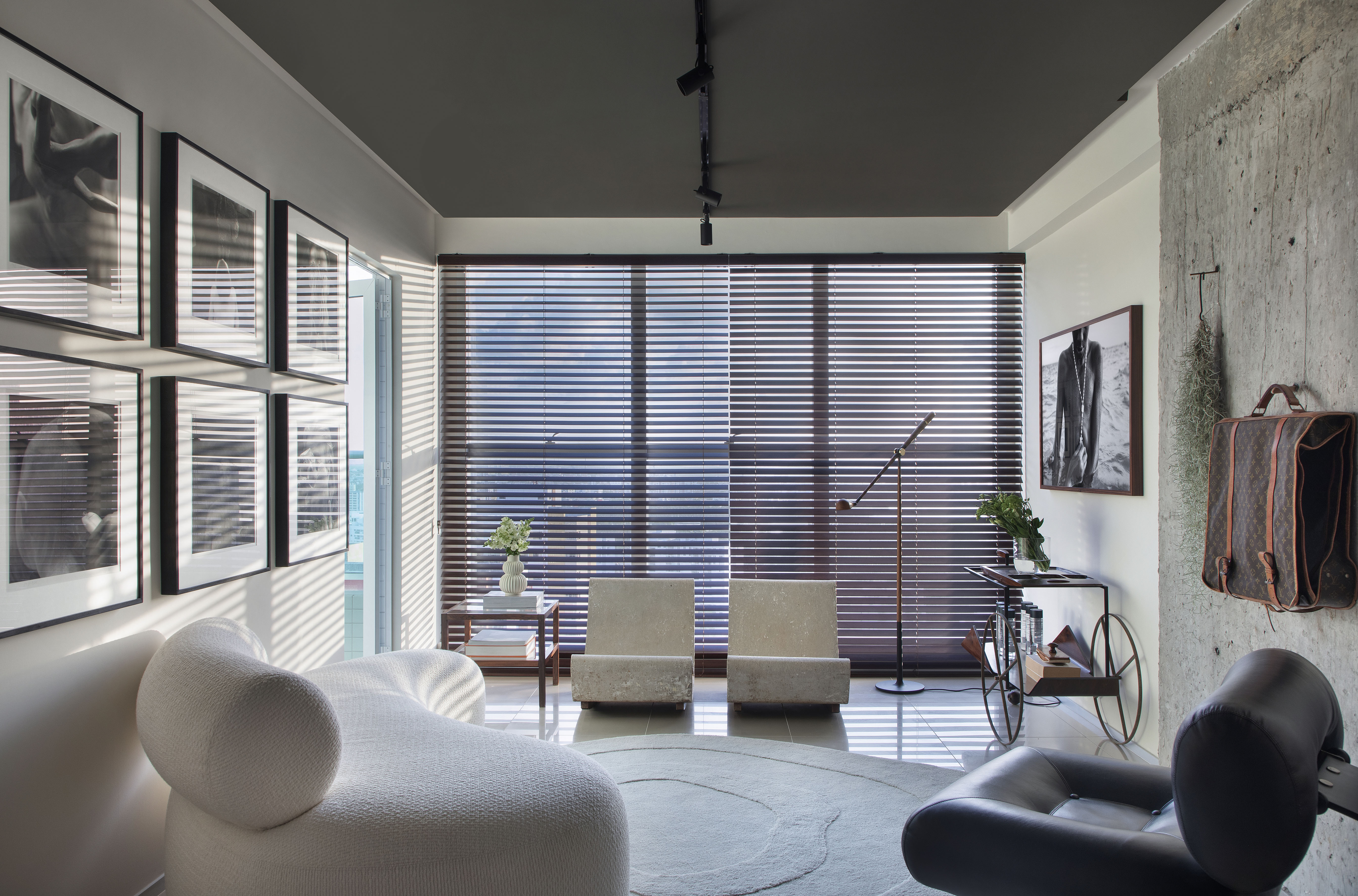 Sala de estar com 25m² é repleta de obras de arte e tons de cinza