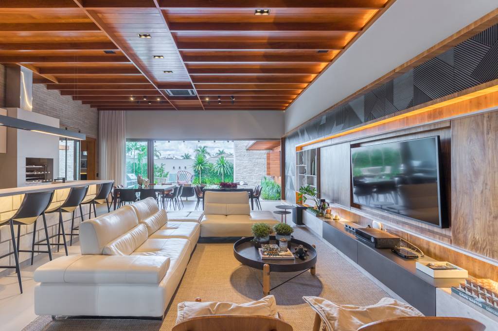 trama-de-paineis-de-madeira-articulaveis-casa-375m-truvian-arquitetura-fotos-leo-matsuda-11 Sala integrada; cozinha integrada; cozinha americana; área gourmet; sofá branco; sala de tv