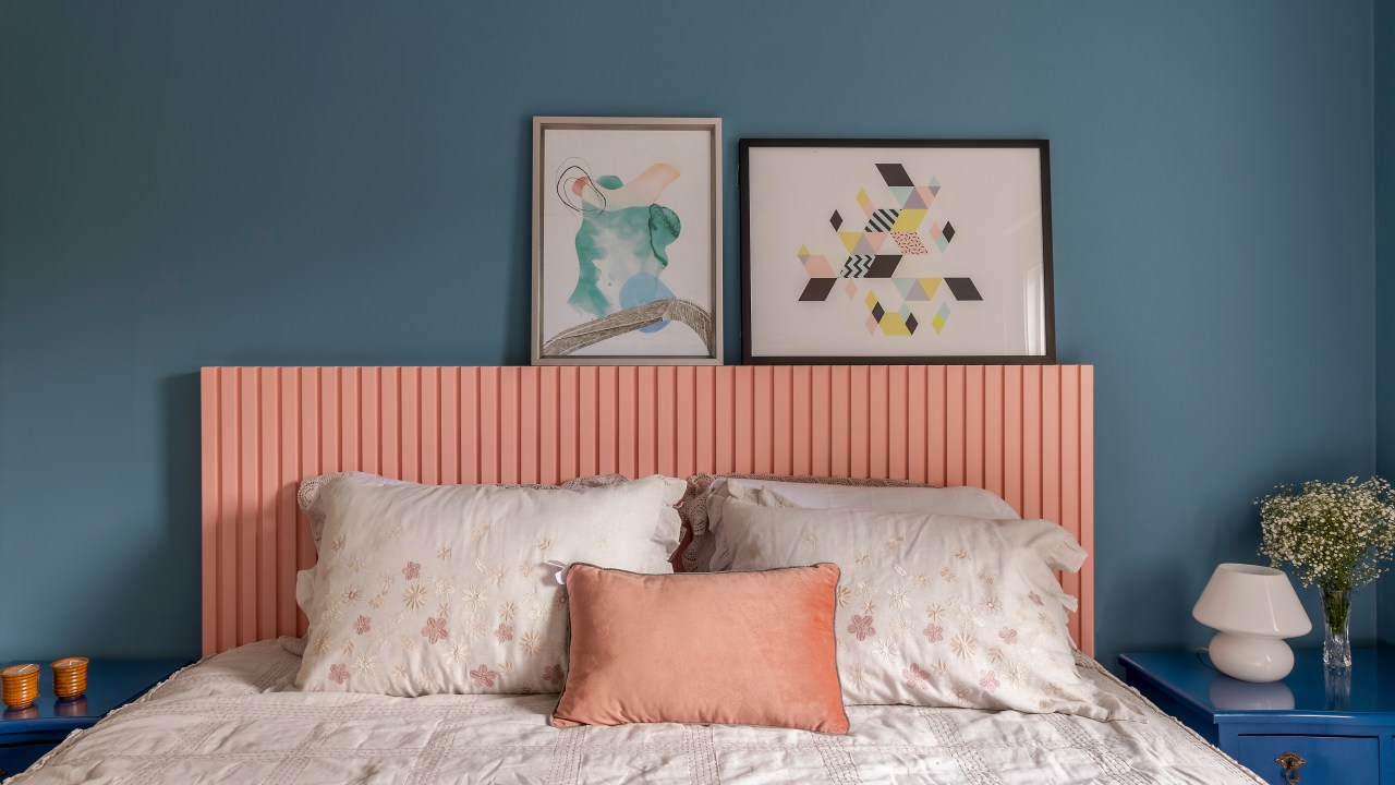 Quarto; cabeceira de madeira ripada; cabeceira rosa; parede azul; quadros; cama de casal