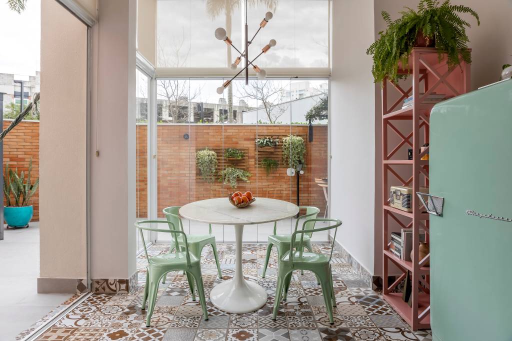 Sala de jantar; mesa redonda branca; luminária; estante rosa; geladeira retrô verde menta