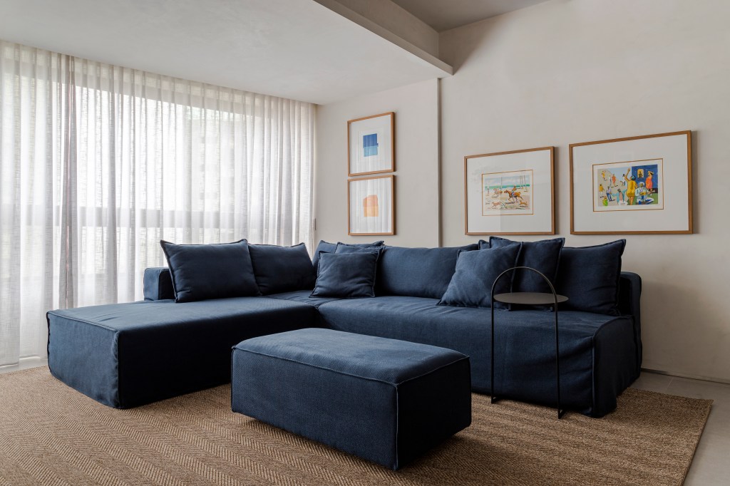 Sala de estar; sofá; sofá azul; quadros; pufe