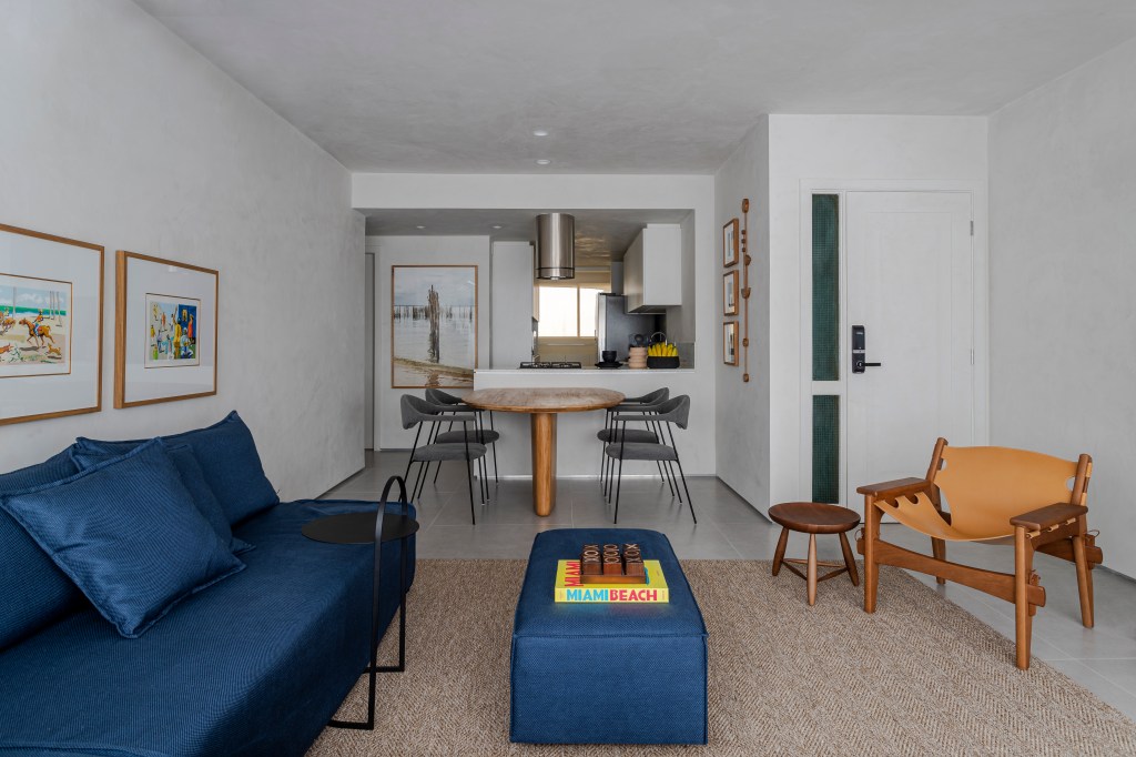 Sala de estar integrada com jantar; cozinha integrada; sofá azul; pufe azul
