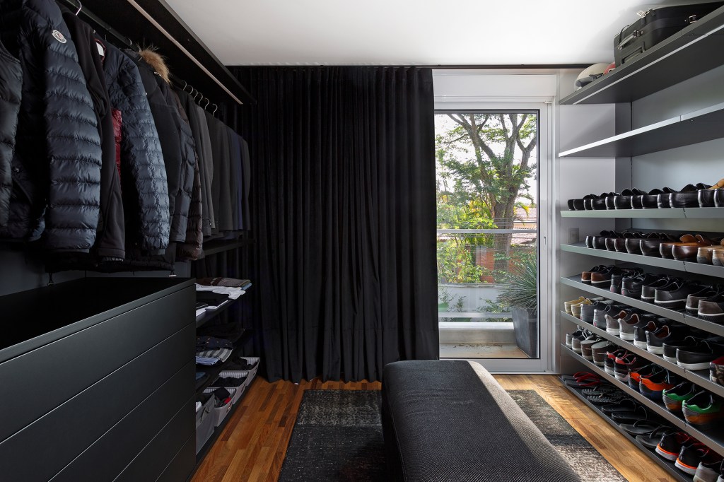 Casa 290 m² ganha cozinha preta com vista para jardim tropical Cadda Arquitetura decoração Carolina Haddad closet preto armario