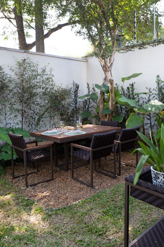 Casa 290 m² ganha cozinha preta com vista para jardim tropical Cadda Arquitetura decoração Carolina Haddad jardim gourmet mesa cadeira