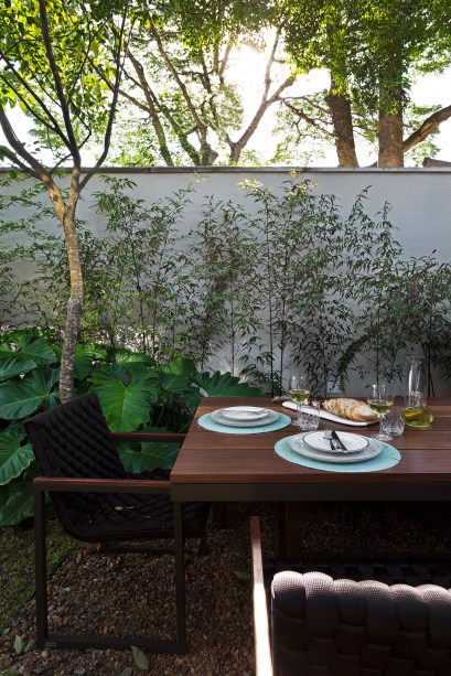 Casa de 290 m² ganha cozinha preta com vista para jardim tropical