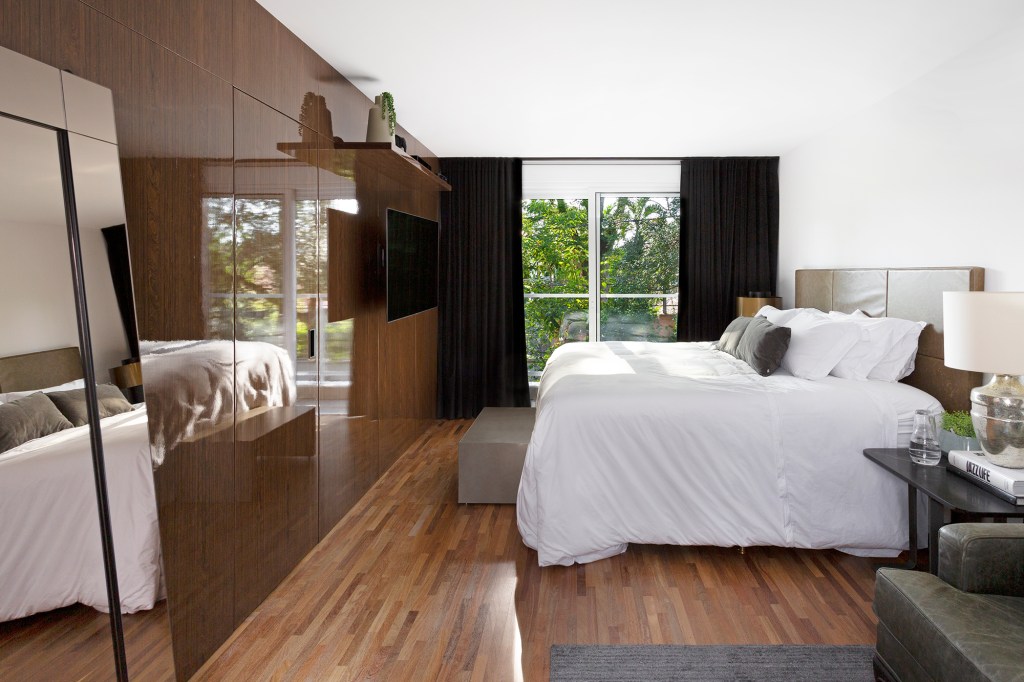 Casa 290 m² ganha cozinha preta com vista para jardim tropical Cadda Arquitetura decoração Carolina Haddad jardim quarto cama casal cabeceira armario madeira
