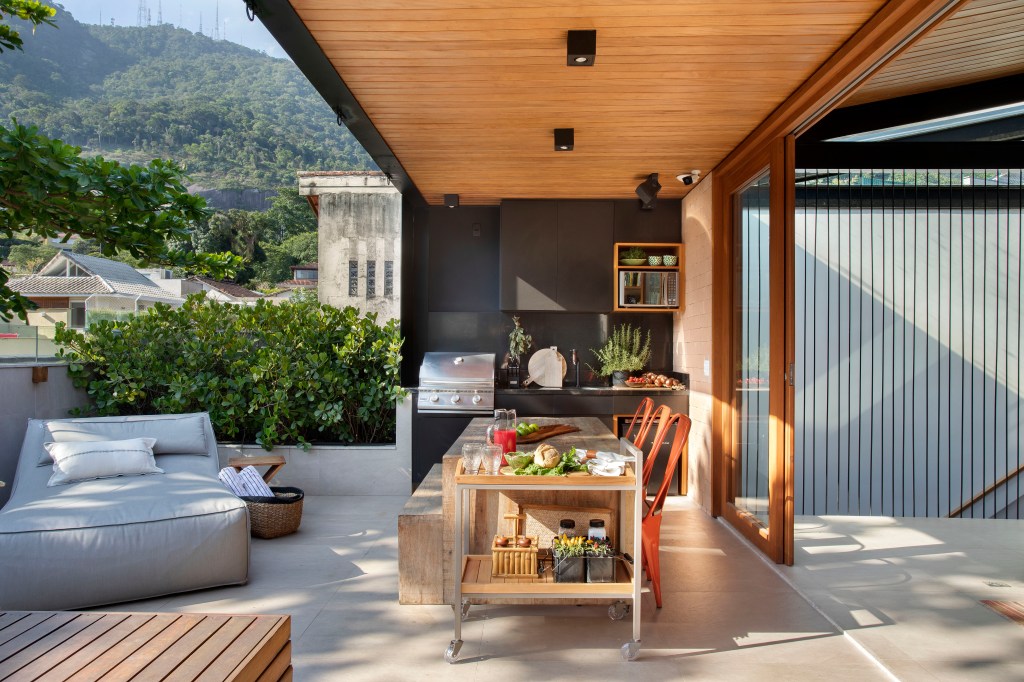 Terraço; varanda; piscina; área gourmet; madeira; mesa de madeira; cadeira vermelha