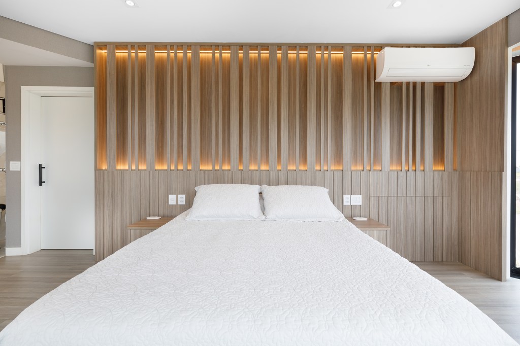 Casa nova decoração tons neutros vista para natureza Yannick Athia quarto cama madeira cabeceira casal