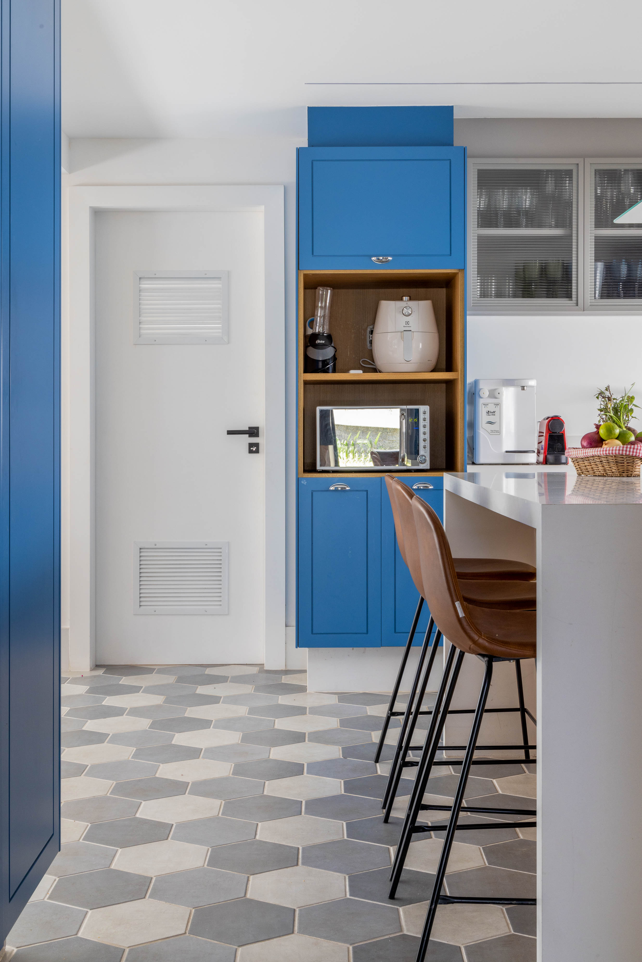 Cozinha em tons de azul e madeira é o destaque desta casa no Rio