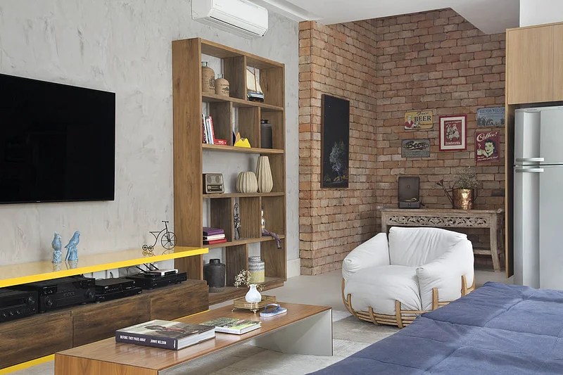 Sala de estar; parede de tijolinho; poltrona branca; sala de tv